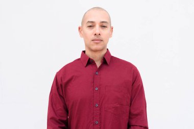Burgonya gömlekli, beyaz arka planda duran kendine güvenen kel, yetişkin bir adam. Stüdyo portre tarzı, temiz, minimal, profesyonel görünüm..