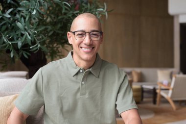 40 'lı yaşlarda Latin bir adam otel kafesinde ya da barda modern iç mimari ile poz veriyor. Vesikalık, zarif iş-gündelik görünüş, rahat tavır, güven ve yakışıklı olgun erkeklik üzerine odaklanmış..