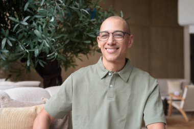 40 'lı yaşlarda Latin bir adam otel kafesinde ya da barda modern iç mimari ile poz veriyor. Vesikalık, zarif iş-gündelik görünüş, rahat tavır, güven ve yakışıklı olgun erkeklik üzerine odaklanmış..