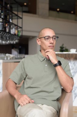 40 'lı yaşlarda Latin bir adam otel kafesinde ya da barda modern iç mimari ile poz veriyor. Şık iş hayatına odaklanmış, rahat tavırlı, kendine güvenen ve yakışıklı olgun erkekliğe odaklanmış..