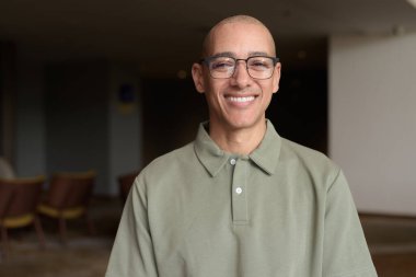 40 'lı yaşlarda Latin bir adam otel kafesinde ya da barda modern iç mimari ile poz veriyor. Vesikalık, zarif iş-gündelik görünüş, rahat tavır, güven ve yakışıklı olgun erkeklik üzerine odaklanmış..