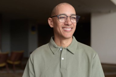 40 'lı yaşlarda Latin bir adam otel kafesinde ya da barda modern iç mimari ile poz veriyor. Vesikalık, zarif iş-gündelik görünüş, rahat tavır, güven ve yakışıklı olgun erkeklik üzerine odaklanmış..