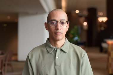 40 'lı yaşlarda Latin bir adam otel kafesinde ya da barda modern iç mimari ile poz veriyor. Şık iş hayatına odaklanmış, rahat tavırlı, kendine güvenen ve yakışıklı olgun erkekliğe odaklanmış..