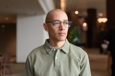 40 'lı yaşlarda Latin bir adam otel kafesinde ya da barda modern iç mimari ile poz veriyor. Şık iş hayatına odaklanmış, rahat tavırlı, kendine güvenen ve yakışıklı olgun erkekliğe odaklanmış..