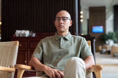 40 'lı yaşlarda Latin bir adam otel kafesinde ya da barda modern iç mimari ile poz veriyor. Şık iş hayatına odaklanmış, rahat tavırlı, kendine güvenen ve yakışıklı olgun erkekliğe odaklanmış..