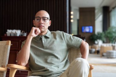 40 'lı yaşlarda Latin bir adam otel kafesinde ya da barda modern iç mimari ile poz veriyor. Şık iş hayatına odaklanmış, rahat tavırlı, kendine güvenen ve yakışıklı olgun erkekliğe odaklanmış..