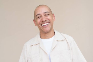 Sıradan bej gömlekli kel bir adamın portresi bej arka planda duruyordu..