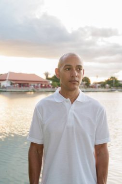 Gün batımında park gölünün yanında mercekli kel ve yakışıklı bir İtalyan 'ın yaz portresi.