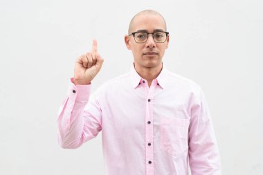 40 'lı yaşlarda, kel, olgun bir erkek. Sıradan pembe iş gömleği ve gözlük takıyor. Düz beyaz duvarın önünde duruyor. Şirket, iş ve yaşam tarzı kavramları için stüdyo tarzı görüntü kullanışlıdır.