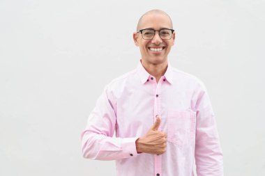 40 'lı yaşlarda, kel, olgun bir erkek. Sıradan pembe iş gömleği ve gözlük takıyor. Düz beyaz duvarın önünde duruyor. Şirket, iş ve yaşam tarzı kavramları için stüdyo tarzı görüntü kullanışlıdır.