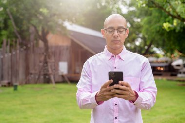 40 'lı yaşlarda kel, olgun bir erkek pembe gömlek ve gözlük takıyor. Kamp alanı çevresi ve karavan geçmişi var. Açık hava eğlence ortamında seyahat, turizm ve yaşam tarzı kavramı.