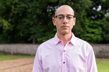 40 'lı yaşlarda kel, olgun bir erkek pembe gömlek ve gözlük takıyor. Kamp alanı çevresi ve karavan geçmişi var. Açık hava eğlence ortamında seyahat, turizm ve yaşam tarzı kavramı.