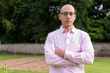 40 'lı yaşlarda kel, olgun bir erkek pembe gömlek ve gözlük takıyor. Kamp alanı çevresi ve karavan geçmişi var. Açık hava eğlence ortamında seyahat, turizm ve yaşam tarzı kavramı.