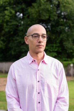 40 'lı yaşlarda kel, olgun bir erkek pembe gömlek ve gözlük takıyor. Kamp alanı çevresi ve karavan geçmişi var. Açık hava eğlence ortamında seyahat, turizm ve yaşam tarzı kavramı.