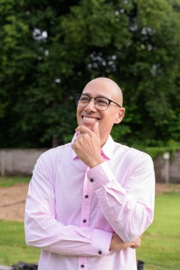 40 'lı yaşlarda kel, olgun bir erkek pembe gömlek ve gözlük takıyor. Kamp alanı çevresi ve karavan geçmişi var. Açık hava eğlence ortamında seyahat, turizm ve yaşam tarzı kavramı.