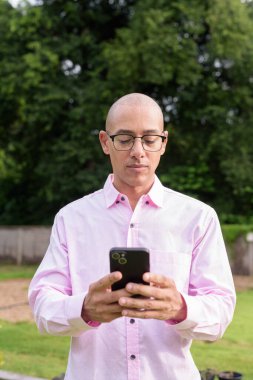 40 'lı yaşlarda kel, olgun bir erkek pembe gömlek ve gözlük takıyor. Kamp alanı çevresi ve karavan geçmişi var. Açık hava eğlence ortamında seyahat, turizm ve yaşam tarzı kavramı.