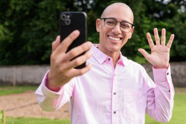 40 'lı yaşlarda kel, olgun bir erkek pembe gömlek ve gözlük takıyor. Kamp alanı çevresi ve karavan geçmişi var. Açık hava eğlence ortamında seyahat, turizm ve yaşam tarzı kavramı.