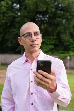 40 'lı yaşlarda kel, olgun bir erkek pembe gömlek ve gözlük takıyor. Kamp alanı çevresi ve karavan geçmişi var. Açık hava eğlence ortamında seyahat, turizm ve yaşam tarzı kavramı.