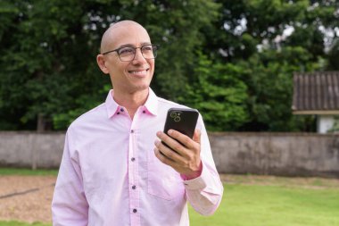 40 'lı yaşlarda kel, olgun bir erkek pembe gömlek ve gözlük takıyor. Kamp alanı çevresi ve karavan geçmişi var. Açık hava eğlence ortamında seyahat, turizm ve yaşam tarzı kavramı.