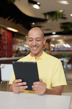 Modern bir lokantada dijital tablet bilgisayarla çalışan kel bir İtalyan 'ın portresi.