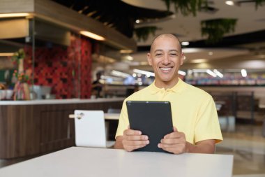 Modern bir lokantada dijital tablet bilgisayarla çalışan kel bir İtalyan 'ın portresi.