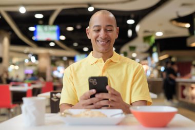 Yetişkin, kel bir İtalyan 'ın portresi modern bir lokantada oturmuş sağlıklı Hainanese tavuğu pilavı yiyor..