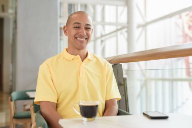 Gündüzleri kahve molası verirken şık bir kafede oturan kendinden emin, kel bir İtalyan. Modern yaşam tarzı ve iş konsepti.