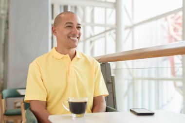 Gündüzleri kahve molası verirken şık bir kafede oturan kendinden emin, kel bir İtalyan. Modern yaşam tarzı ve iş konsepti.