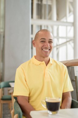 Gündüzleri kahve molası verirken şık bir kafede oturan kendinden emin, kel bir İtalyan. Modern yaşam tarzı ve iş konsepti.