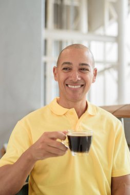 Gündüzleri kahve molası verirken şık bir kafede oturan kendinden emin, kel bir İtalyan. Modern yaşam tarzı ve iş konsepti.