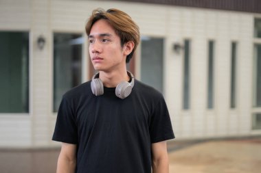 Modern yaşam tarzı fotoğrafçılığı için poz veren Taylandlı genç bir adamın portresi. Çeşitli kavramlar ve kullanımlar için kendine güvenen, rahat ve otantik görünüm