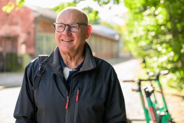 Parkta bisikleti olan gülümseyen son sınıf öğrencisinin portresi.