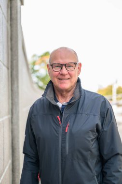Portrait of a smiling senior man with eyeglasses in the city