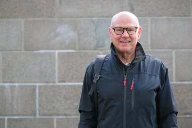 Portrait of a smiling Scandinavian senior man wearing sportswear in the city