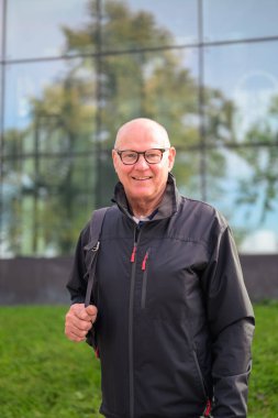 Portrait of a smiling Scandinavian senior man in sportswear standing outdoors