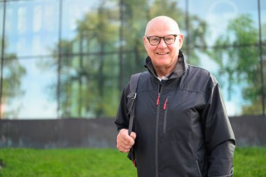 Portrait of a smiling Scandinavian senior man in sportswear standing outdoors
