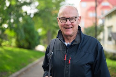 Portrait of a smiling Nordic senior man in sportswear standing outdoors