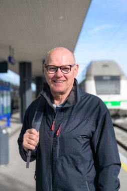 Portrait of smiling senior man with eyeglasses at train station