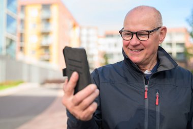 Portrait of a mature man using his mobile phone in the city