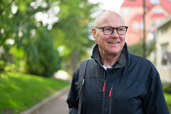 Portrait of a smiling Nordic senior man in sportswear standing outdoors