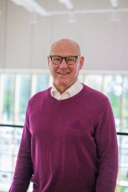Portrait of a smiling senior man standing in living room at home