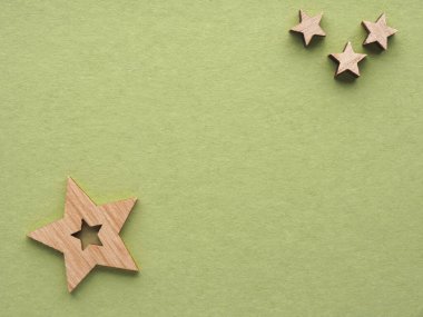 Yeşil kağıtta tahta yıldızlı Noel arkaplanı, geleneksel Noel kartı.