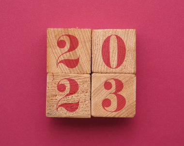 Yıl 2023 ile ahşap bloklar macenta kağıt levha üzerinde, 2023 konsept arkaplan rengi