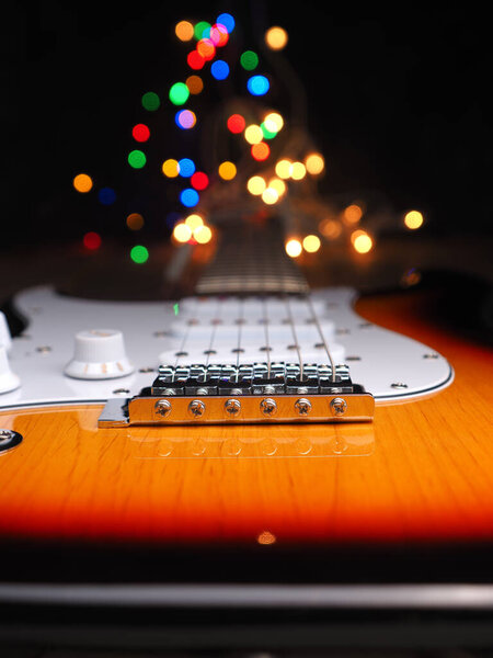 Old used vintage guitar with colorful Christmas lights bokeh background and space for your text