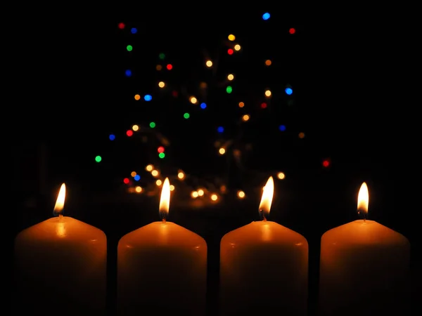 四支点燃着五彩缤纷圣诞彩灯背景的小蜡烛 为你的文字留出空间 — 图库照片