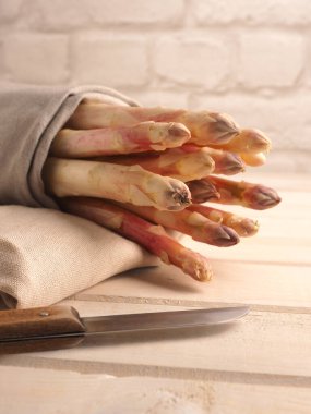 Kırsal ahşap mutfak masasında lezzetli organik, mor kuşkonmaz. Kapalı, sağlıklı yiyecekler.