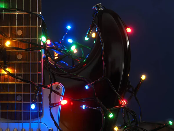 素朴な木の背景にクリスマスのライトが付いている古い使用されたヴィンテージの電気ギター — ストック写真