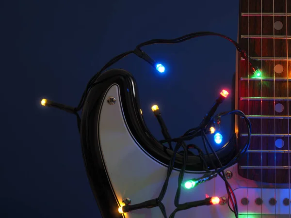ダークブルーの背景にクリスマスライト付き古いヴィンテージエレクトリックギター — ストック写真