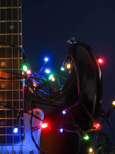 ダークブルーの背景にクリスマスライト付き古いヴィンテージエレクトリックギター — ストック写真