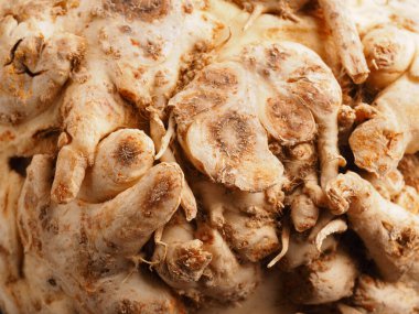 Kahverengi ahşap mutfak masasında organik kök kerevizi, sağlıklı yiyecekler, mevsimlik sebzeler, makroyu kapat.